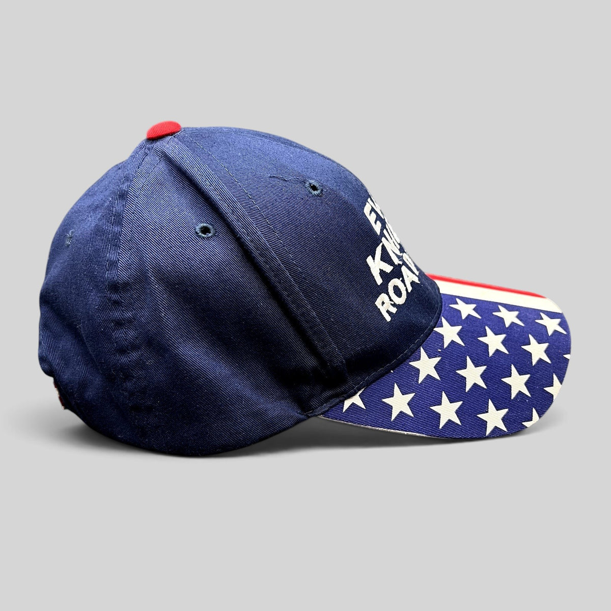 Raree Finds Y2K Evel Knievel Road Crew navy blue strapback hat with an American flag print brim and white embroidery.