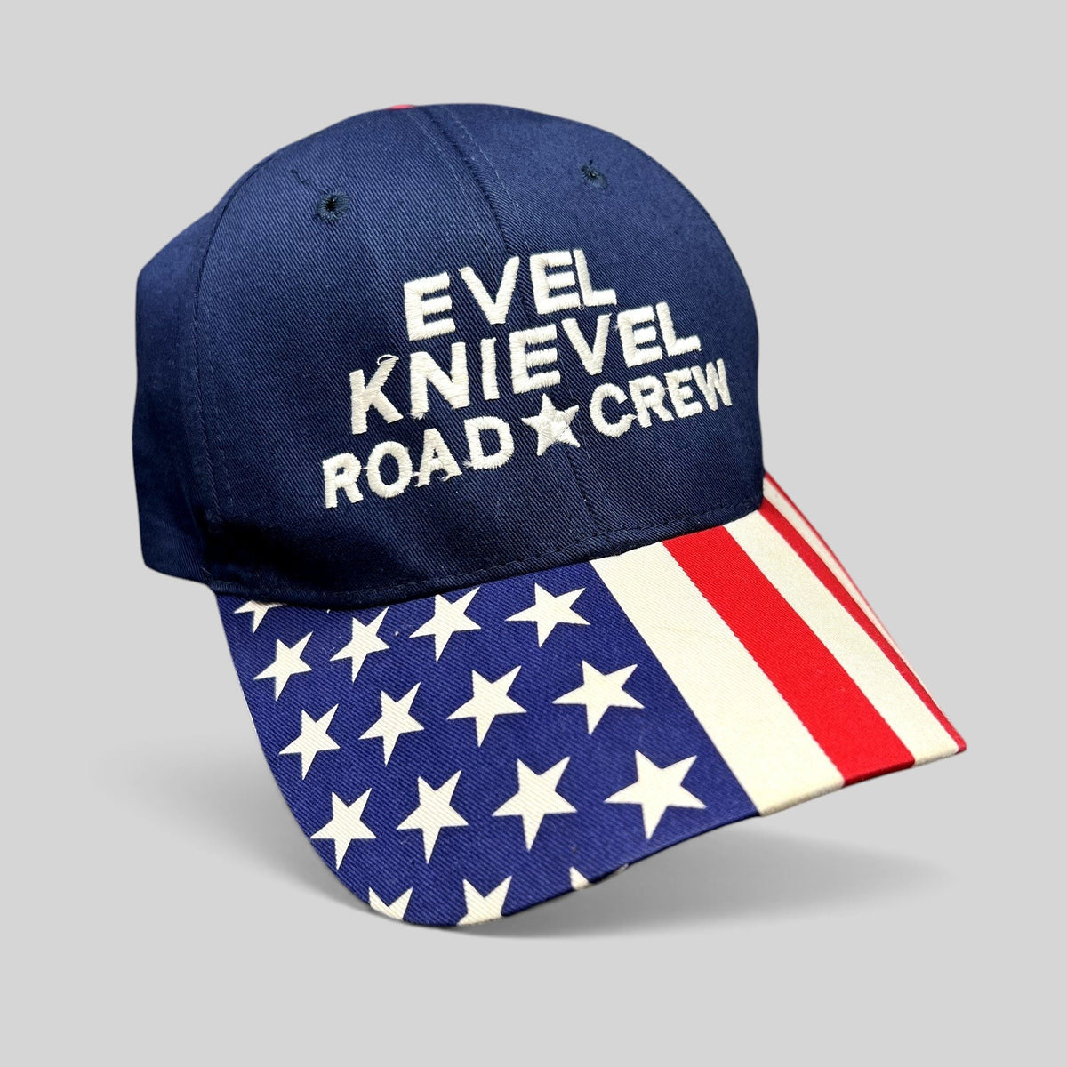 Raree Finds navy blue Evel Knievel Road Crew strapback hat with an American flag print brim and white embroidery.