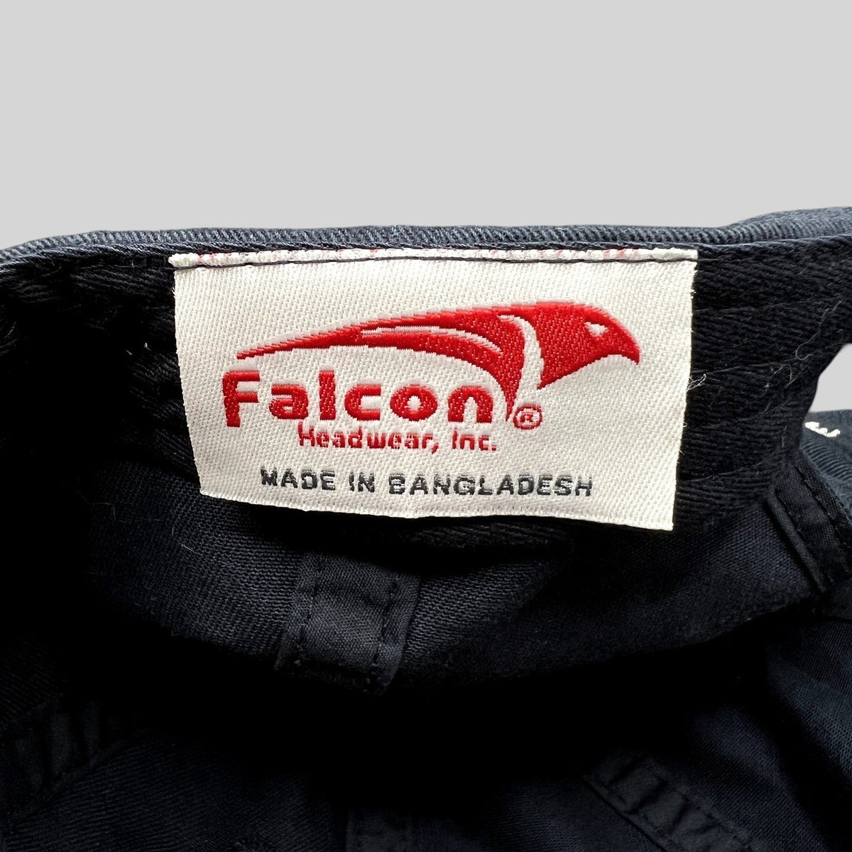 Raree Finds black cotton hat interior label featuring the red Falcon Headwear logo and Made in Bangladesh text