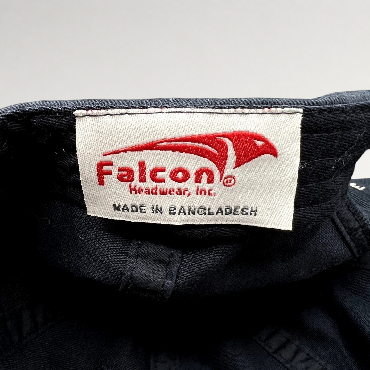 Raree Finds black cotton hat interior label featuring the red Falcon Headwear logo and Made in Bangladesh text