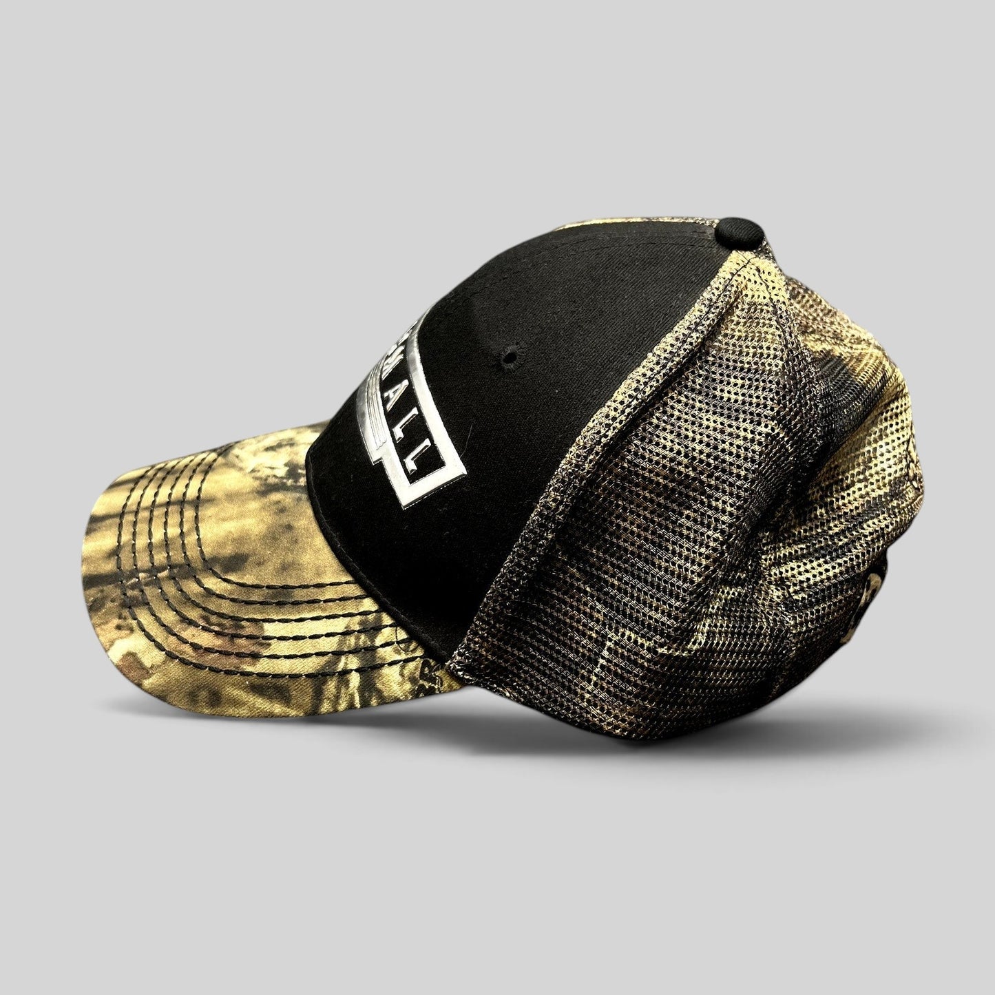 Raree Finds Farmall trucker hat with black cotton crown, camouflage brim, and mesh back panels featuring a logo patch.