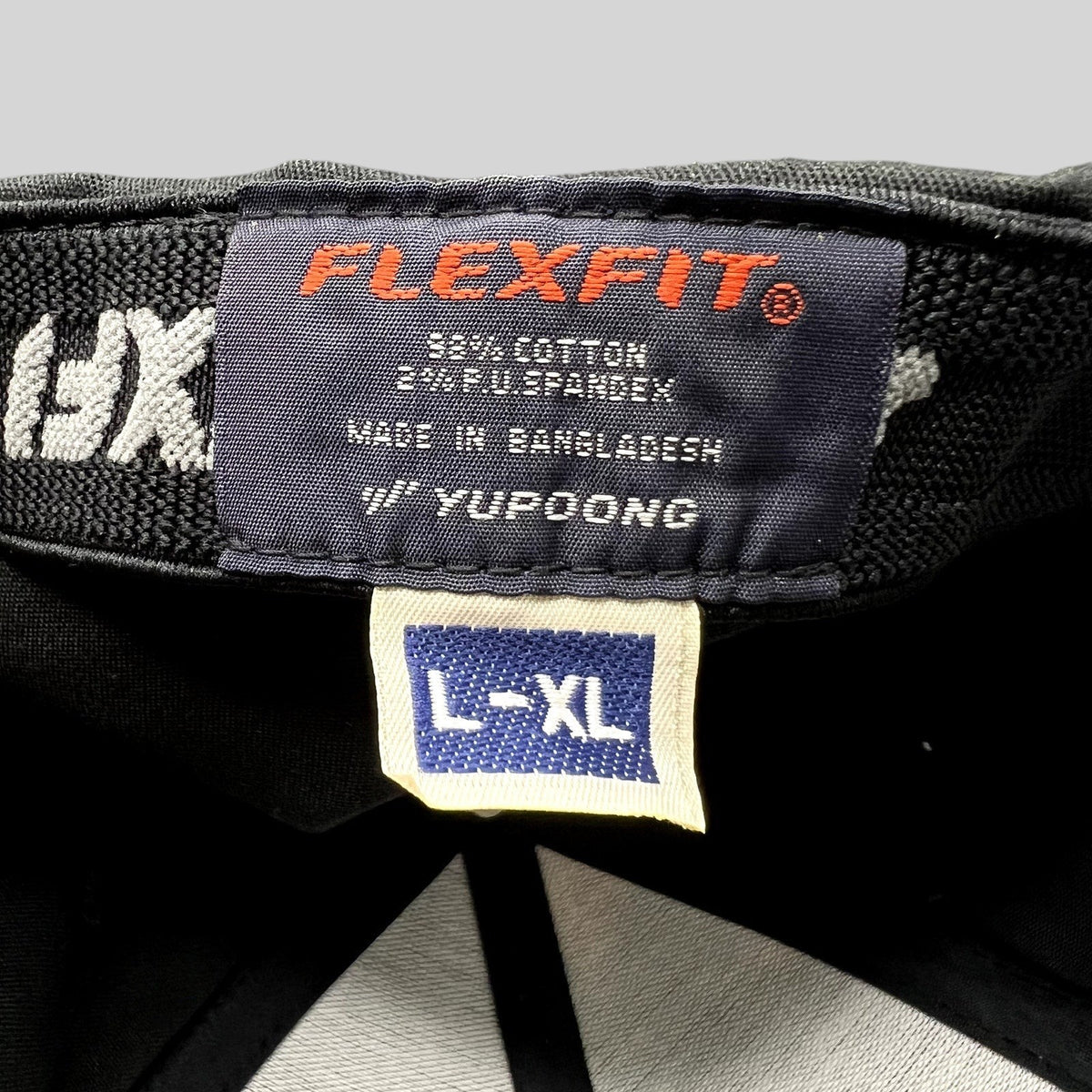 Raree Finds black Flexfit golf cap interior label showing size L/XL and cotton spandex material composition