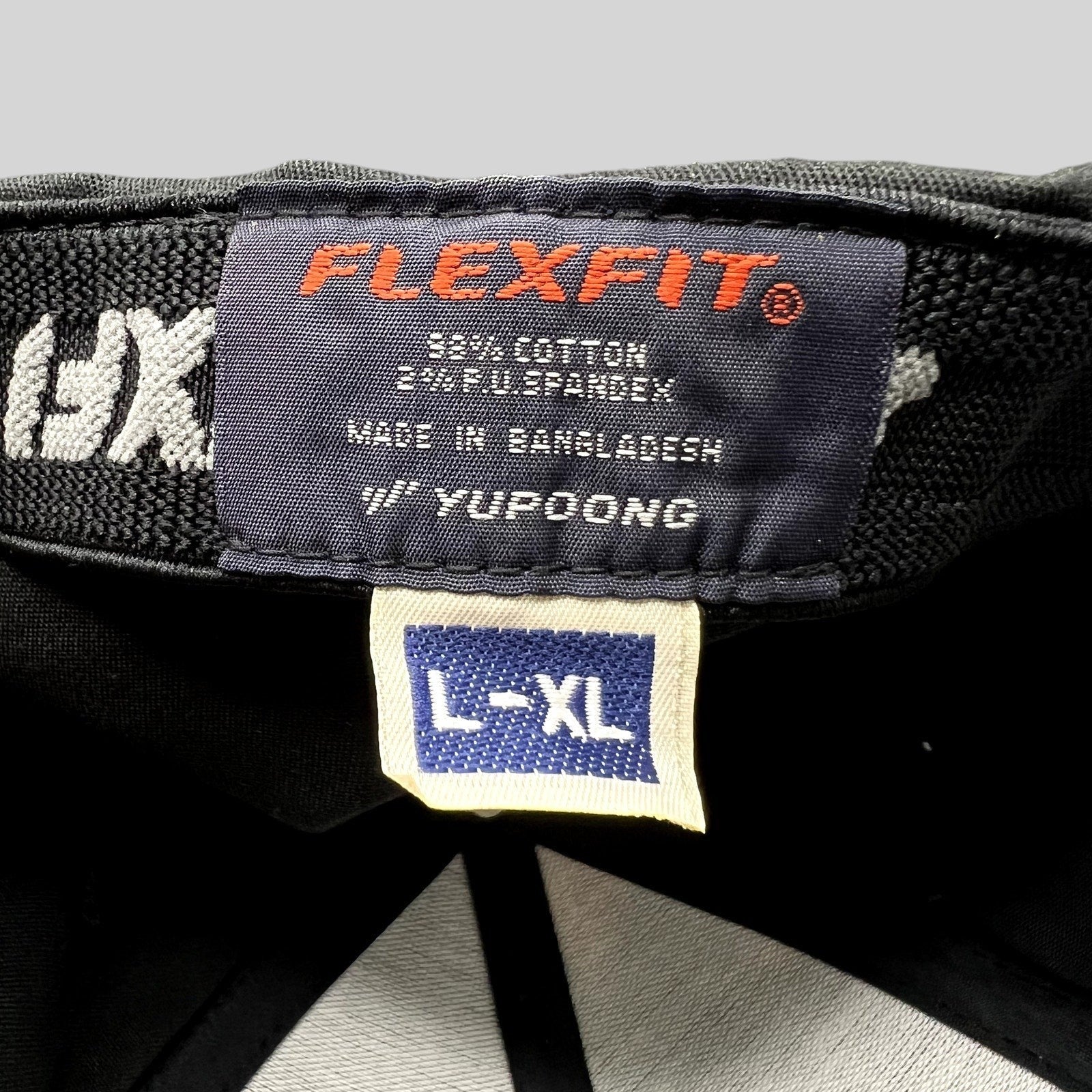 Raree Finds black Flexfit golf cap interior label showing size L/XL and cotton spandex material composition