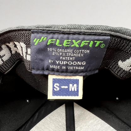 Raree Finds black Yupoong Flexfit hat interior label showing size S-M, organic cotton blend, and Vietnam origin.