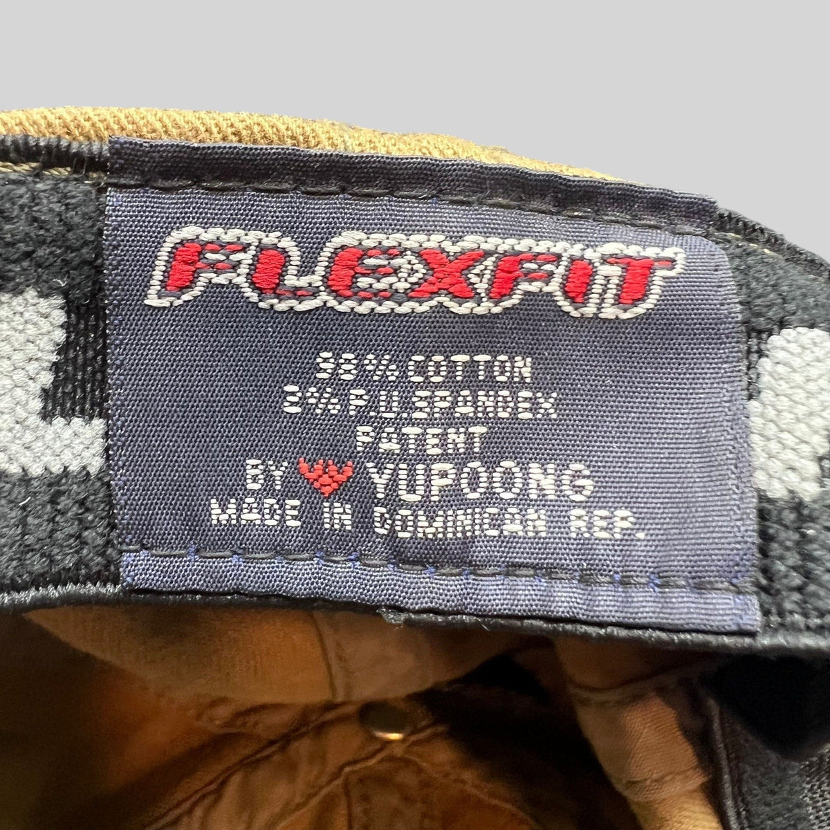 Raree Finds Flexfit hat interior label showing cotton spandex material composition and Yupoong manufacturing details
