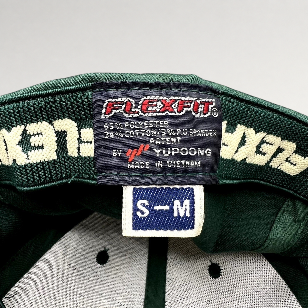 Raree Finds forest green Hanalei Canoe Club hat interior showing Yupoong Flexfit tag and size S/M label