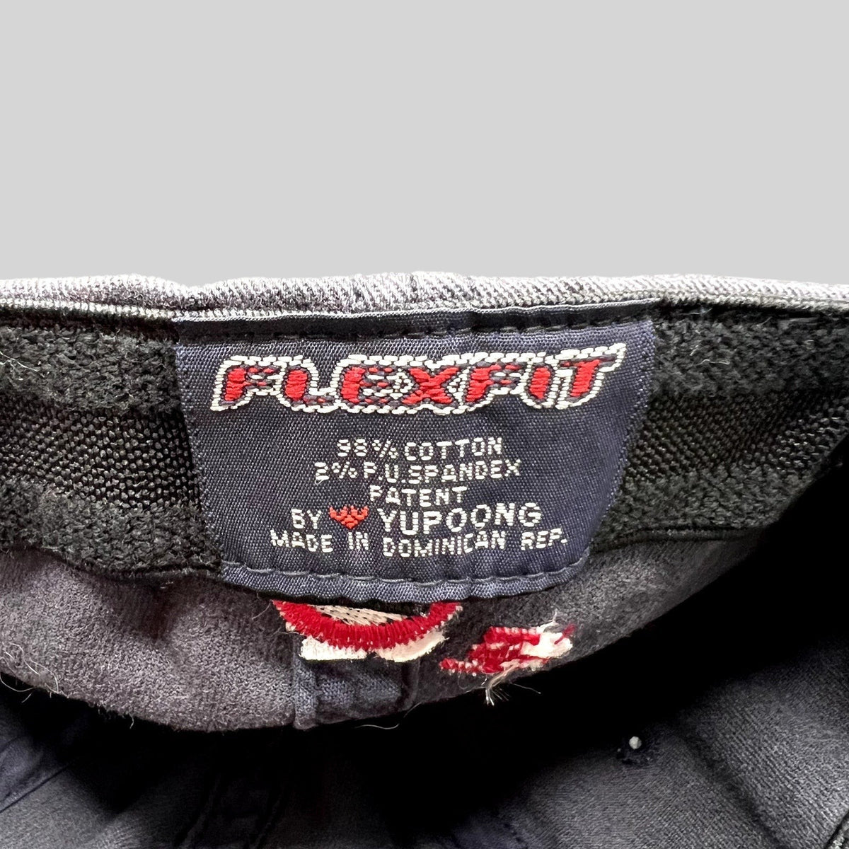Raree Finds vintage Flexfit hat interior tag showing Yupoong branding, material composition, and origin details.