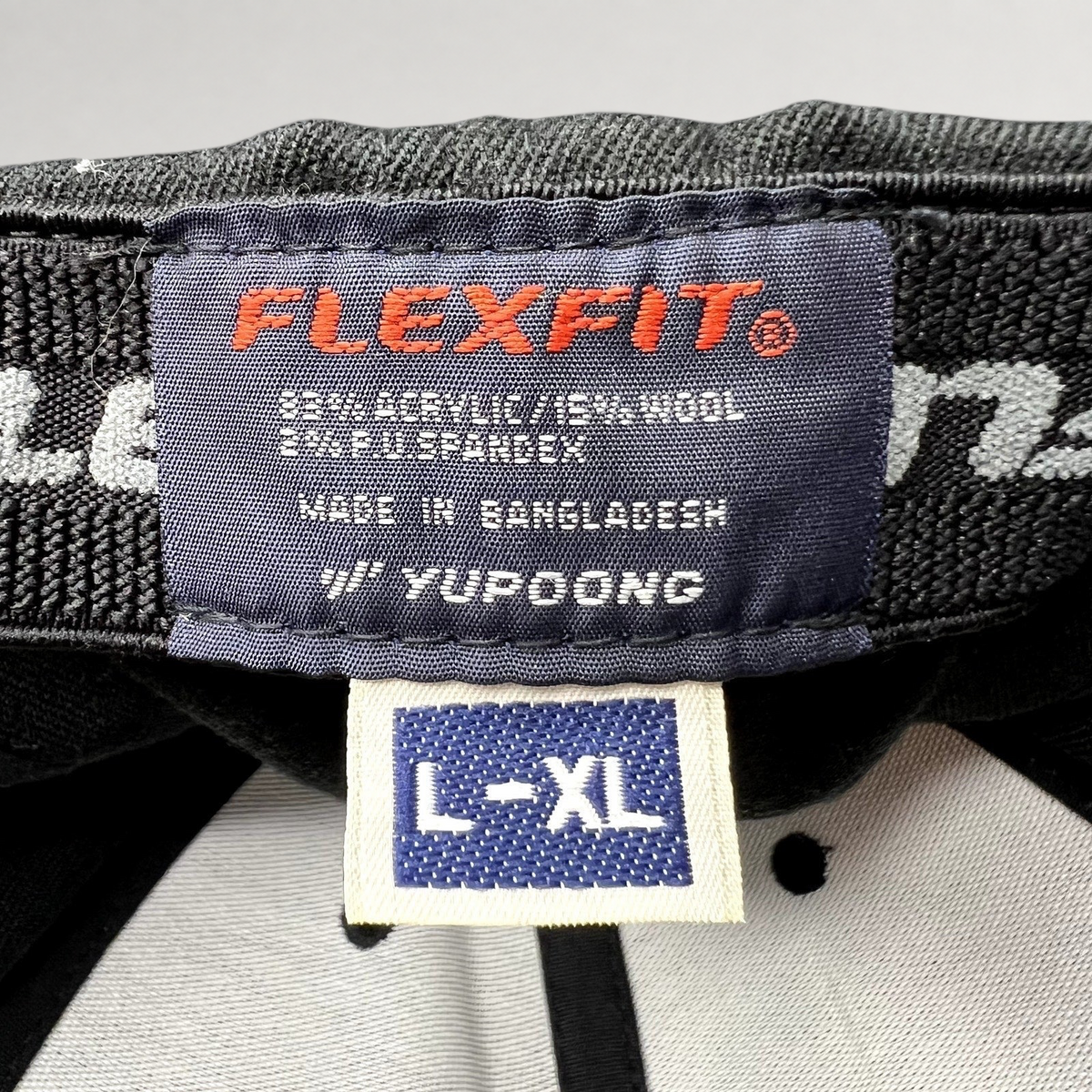 Raree Finds black Flexfit Yupoong hat interior label showing size L/XL and material composition