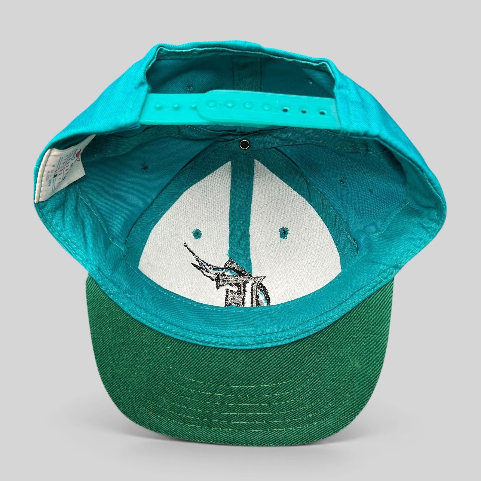 Raree Finds vintage Florida Marlins youth snapback cap showing the interior teal crown, green undervisor, and snapback.