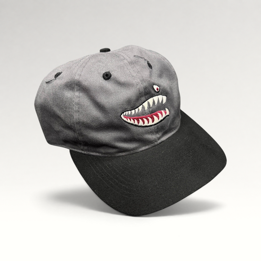 Raree Finds vintage Otto Cap snapback featuring embroidered P-40 Warhawk shark mouth art on a gray and black hat.