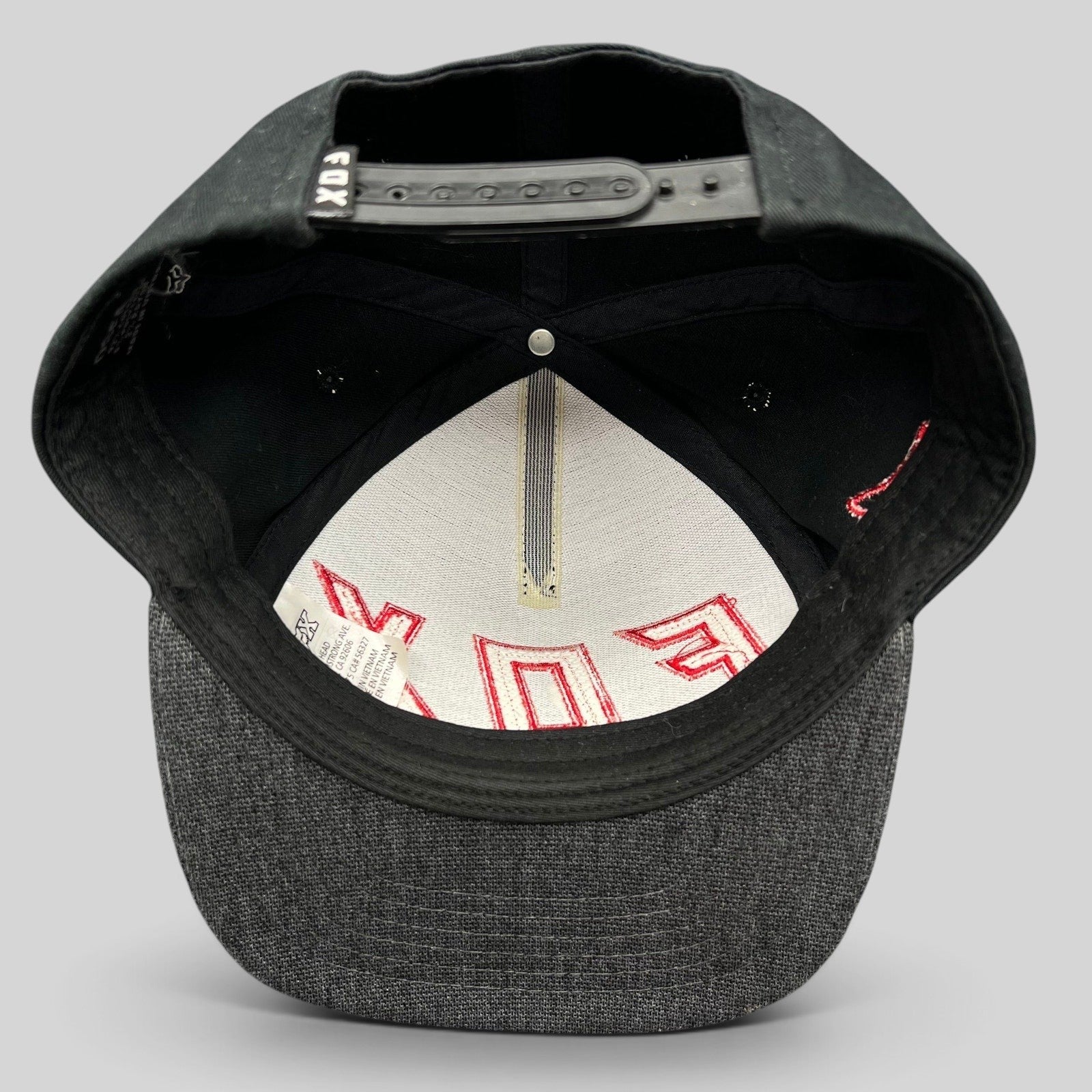 Raree Finds Fox Racing snapback hat interior view showing black crown, gray flat bill, and adjustable plastic strap