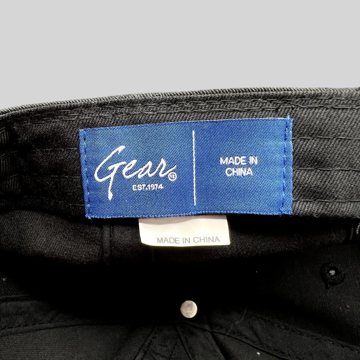 Raree Finds Gear brand blue interior label on a black cotton twill Kalamazoo College strapback dad cap