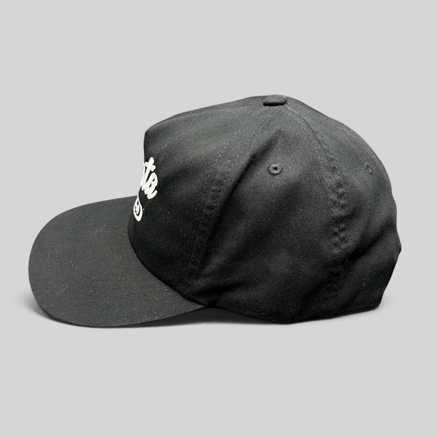 Raree Finds Ggiata LA black snapback hat with white cursive script logo and flat brim on a structured crown.