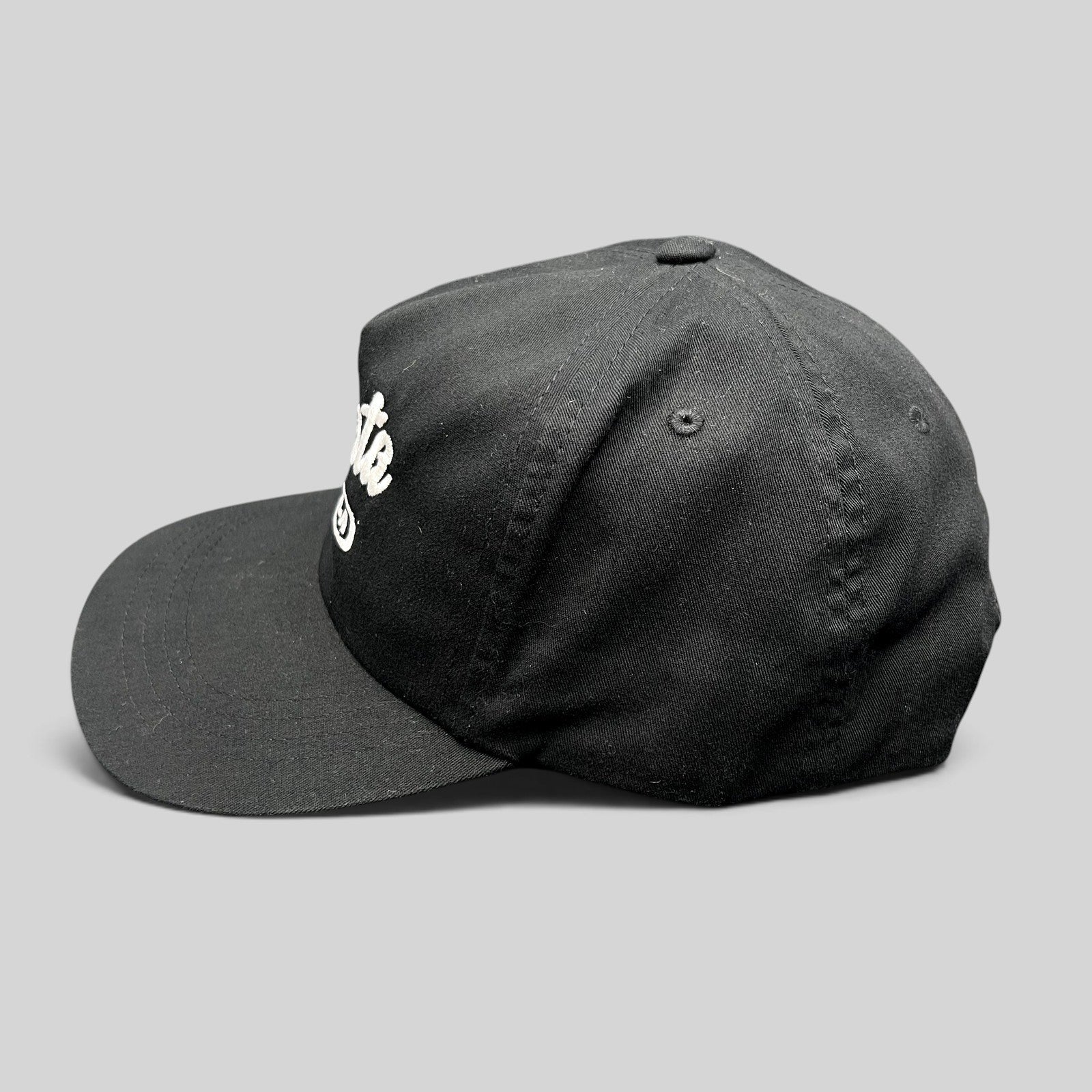Raree Finds Ggiata LA black snapback hat with white cursive script logo and flat brim on a structured crown.