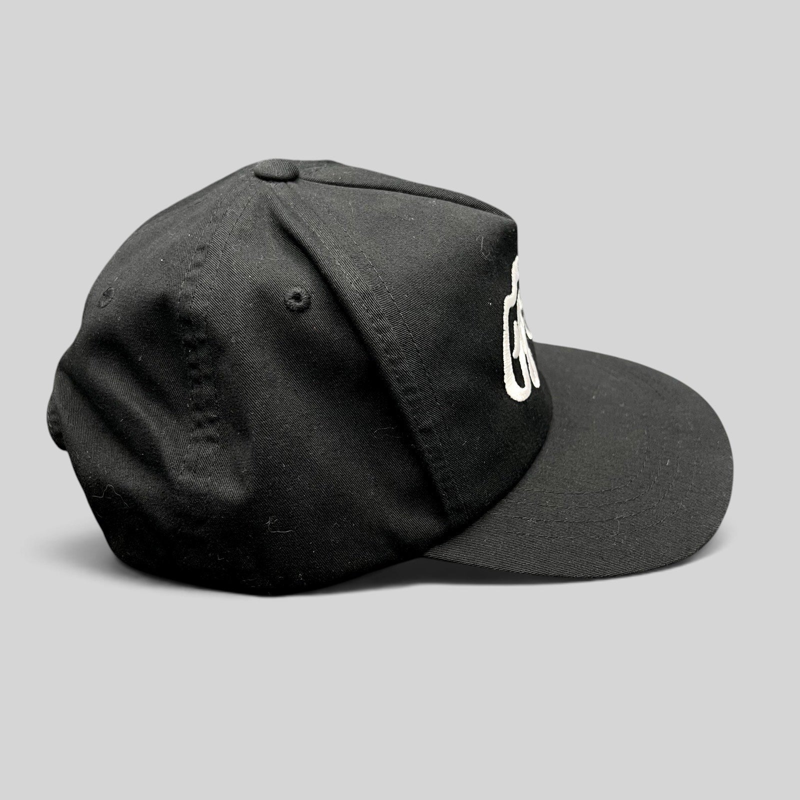 Raree Finds Ggiata LA black snapback hat with white embroidered script logo and flat brim on a structured crown