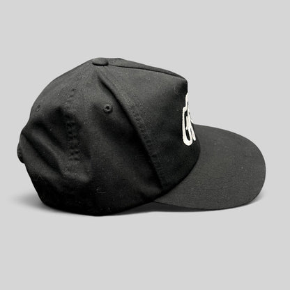 Raree Finds Ggiata LA black snapback hat with white embroidered script logo and flat brim on a structured crown