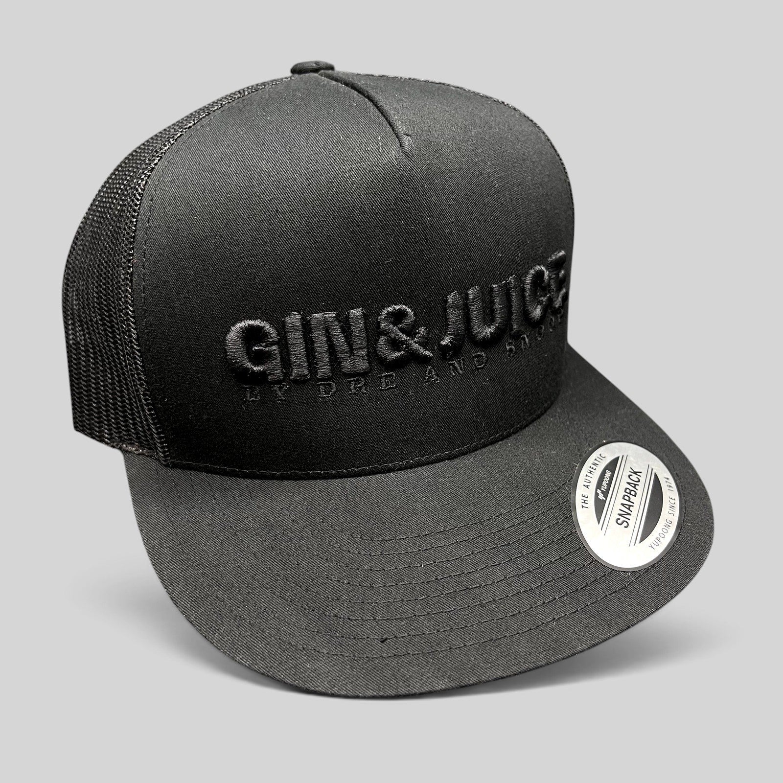 Raree Finds Gin & Juice black trucker snapback hat with tonal raised embroidery and breathable mesh back panels.
