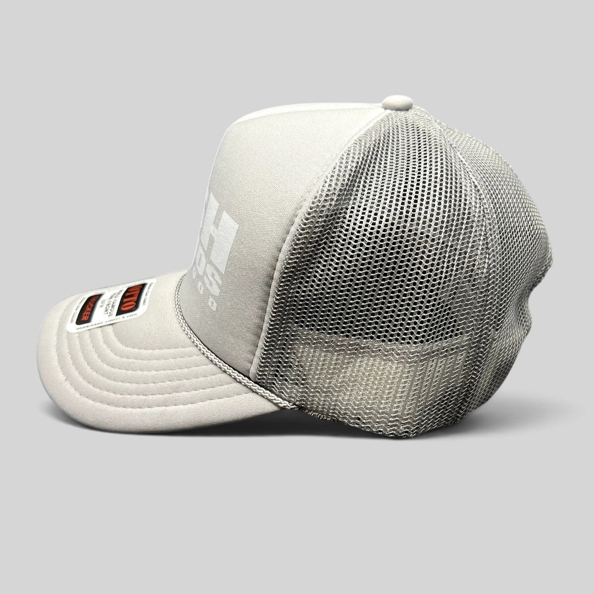 Raree Finds gray RSH Studios Hollywood trucker hat with white print, mesh back, and braided rope detail on the brim.