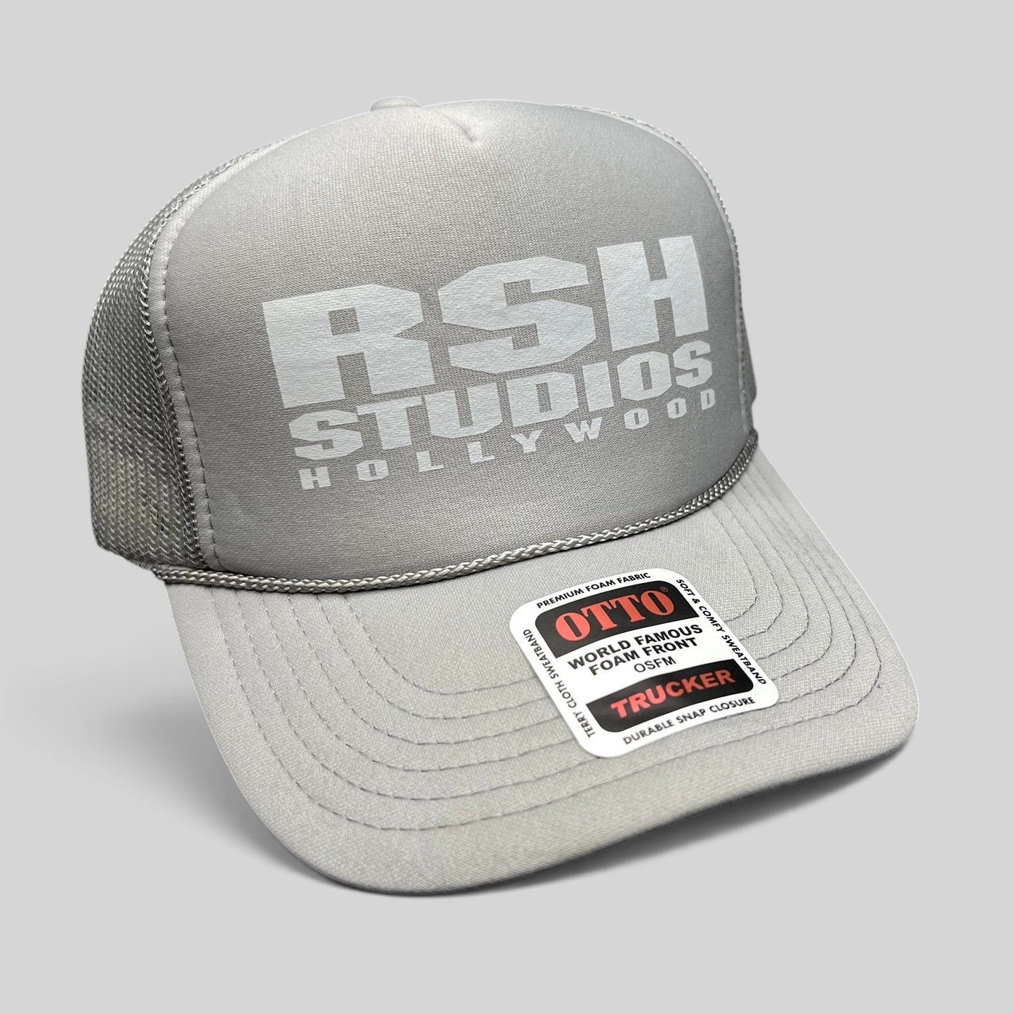 Raree Finds gray RSH Studios Hollywood trucker hat with white print, mesh back, and braided rope detail on the brim.