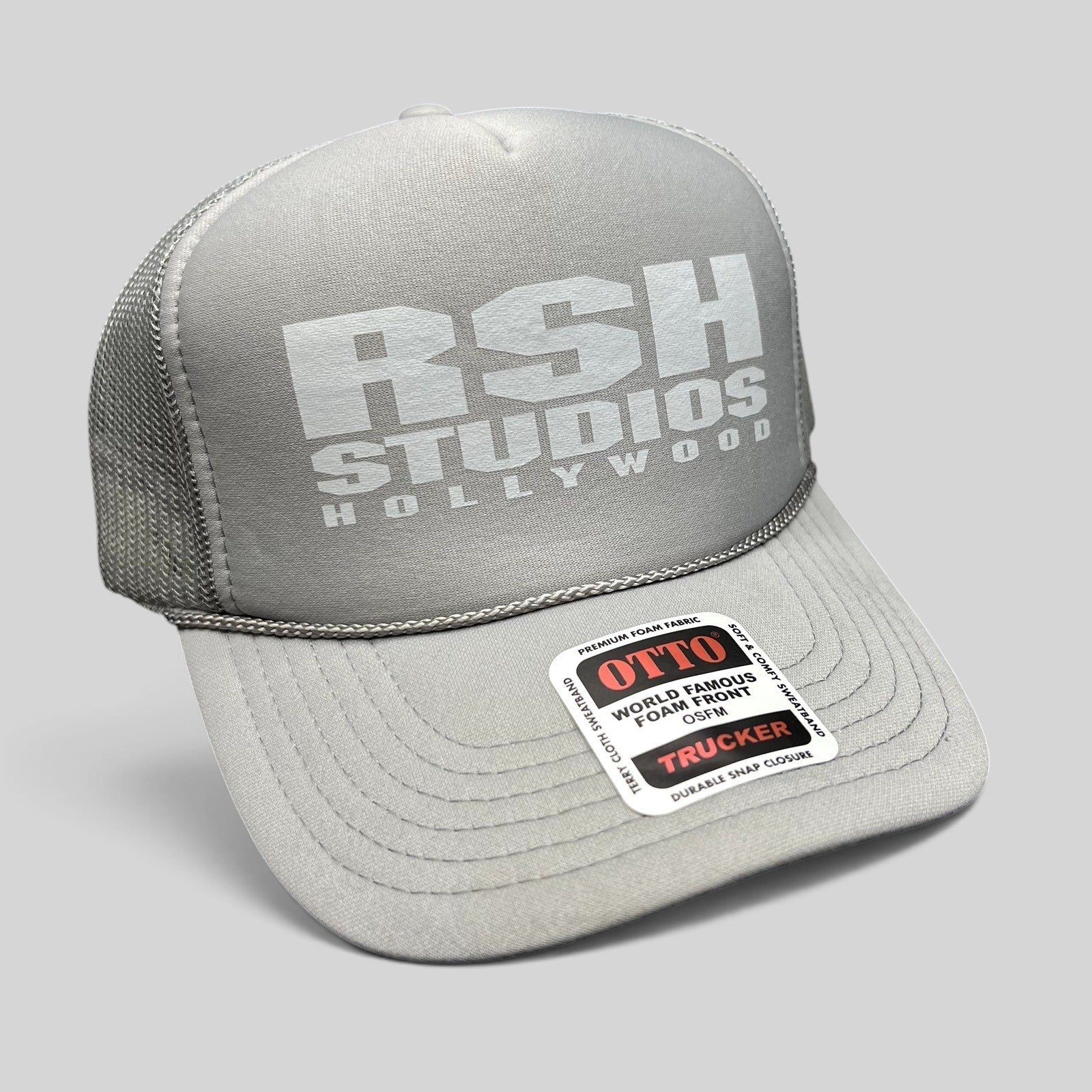 Raree Finds gray RSH Studios Hollywood trucker hat with white print, mesh back, and braided rope detail on the brim.