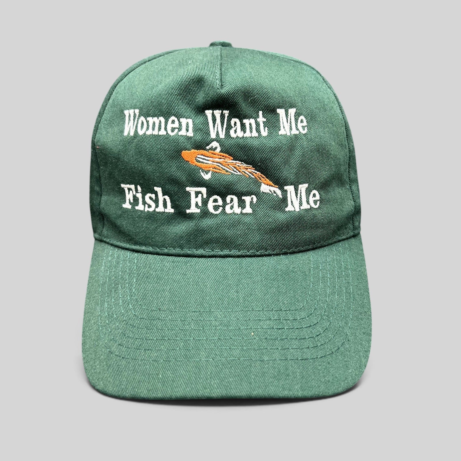 Raree Finds forest green dad cap with Women Want Me Fish Fear Me embroidery and an orange fishing lure graphic.