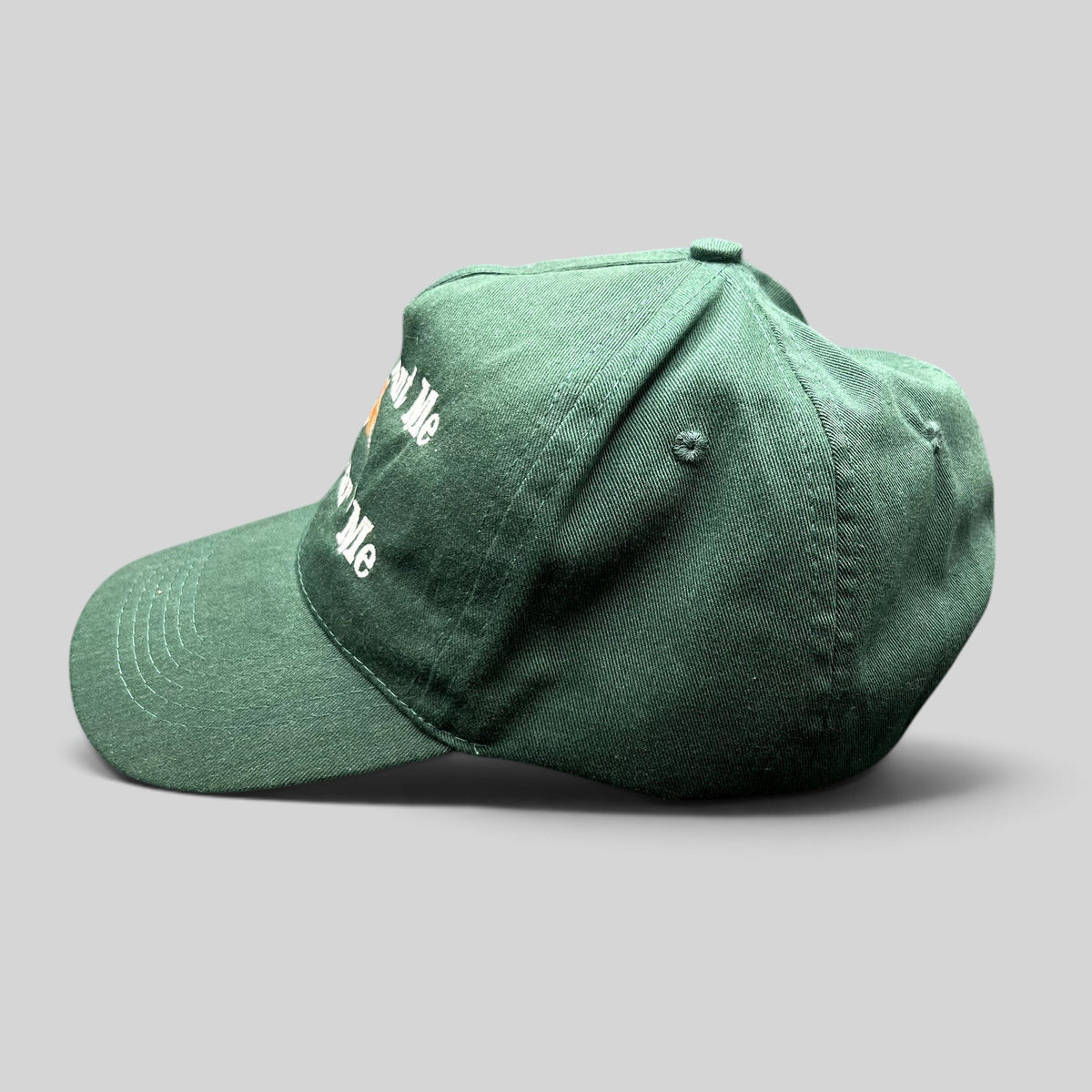 Raree Finds forest green dad cap with Women Want Me Fish Fear Me embroidery and fishing lure graphic, side view.
