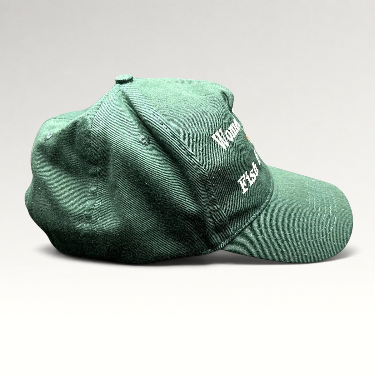 Raree Finds forest green dad cap with Women Want Me Fish Fear Me embroidery and fishing lure graphic, side view.