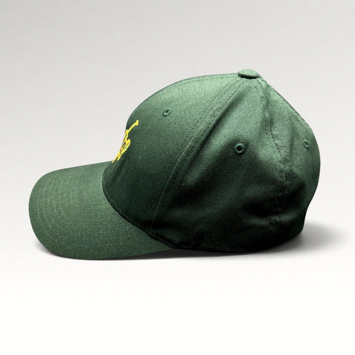 Raree Finds forest green Hanalei Canoe Club Flexfit hat with gold embroidered paddle logo, side profile view.