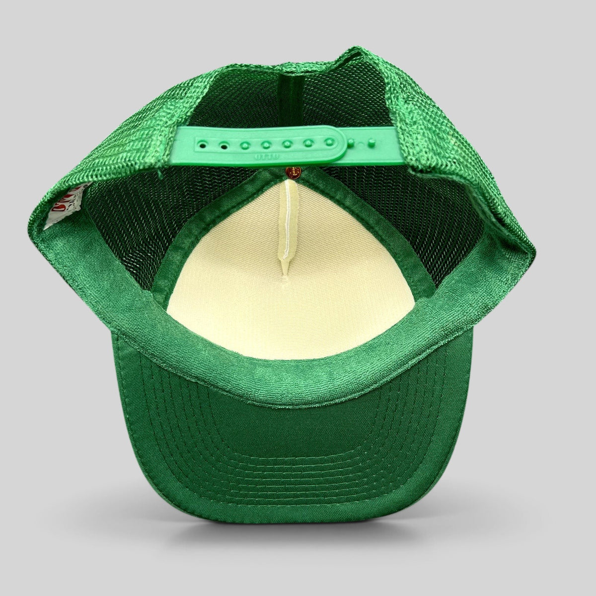 Raree Finds green and white OTTO Collection trucker snapback hat showing the adjustable plastic strap and mesh back