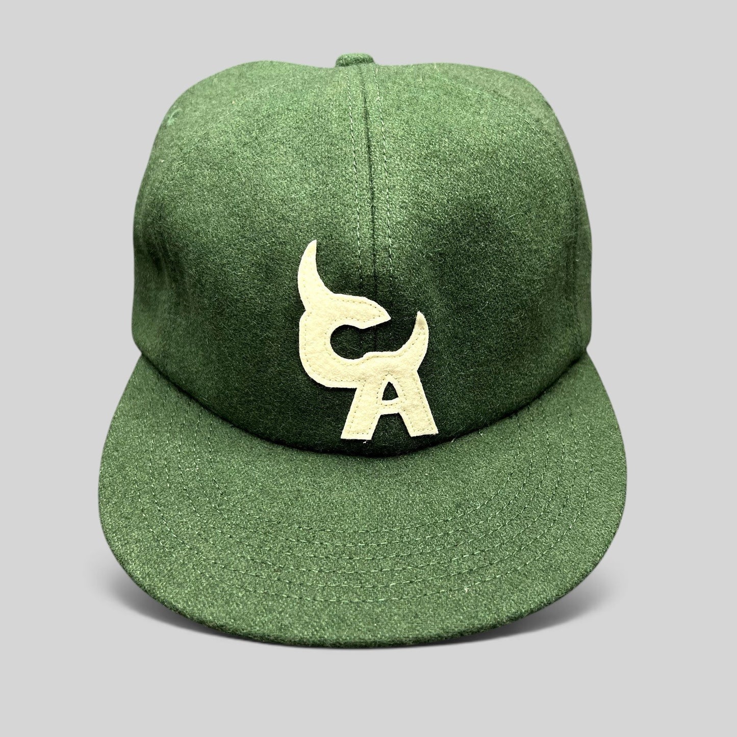 Raree Finds forest green wool-style strapback hat with cream embroidered Chromakopia logo and flat bill design.