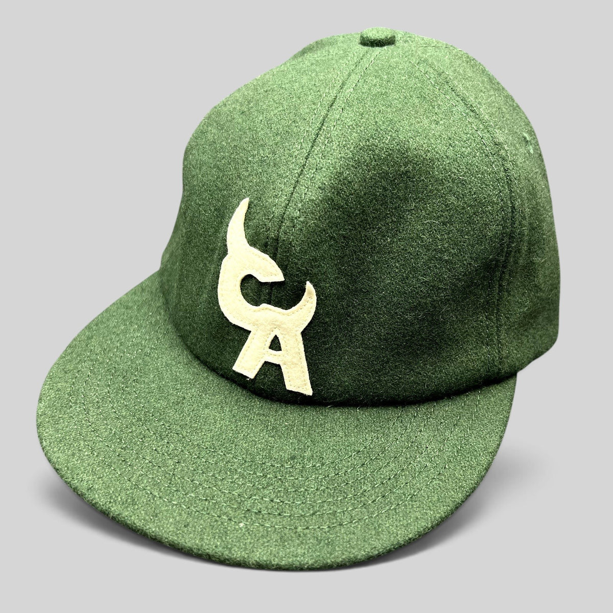 Raree Finds forest green wool-style strapback hat with a large cream embroidered logo on the front