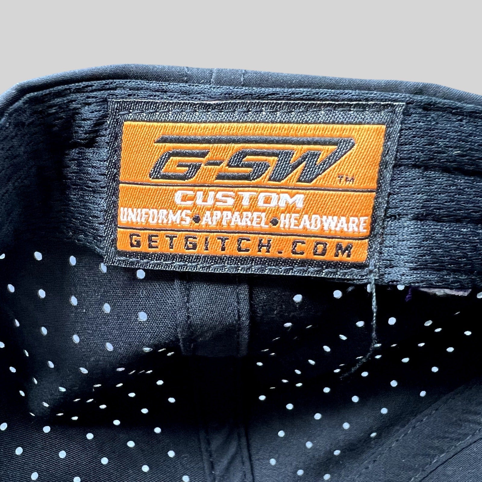 Raree Finds GSW Custom Apparel interior label inside a black perforated snapback hat from The Late Game production