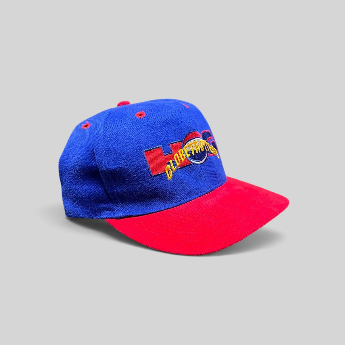Raree Finds vintage 90s Harlem Globetrotters snapback hat with a royal blue crown, red brim, and embroidered logo.