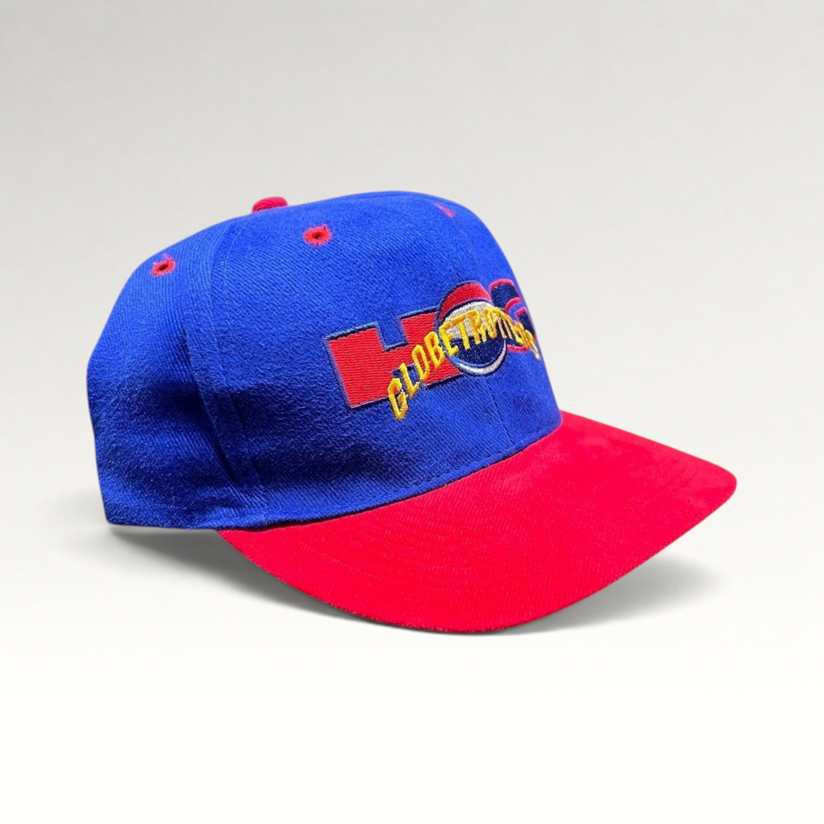 Raree Finds vintage 90s Harlem Globetrotters snapback hat with a royal blue crown, red brim, and embroidered logo.