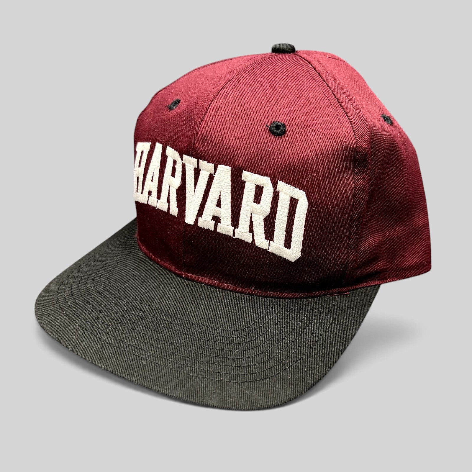 Raree Finds vintage Harvard University snapback hat with crimson crown, black brim, and white embroidered lettering.