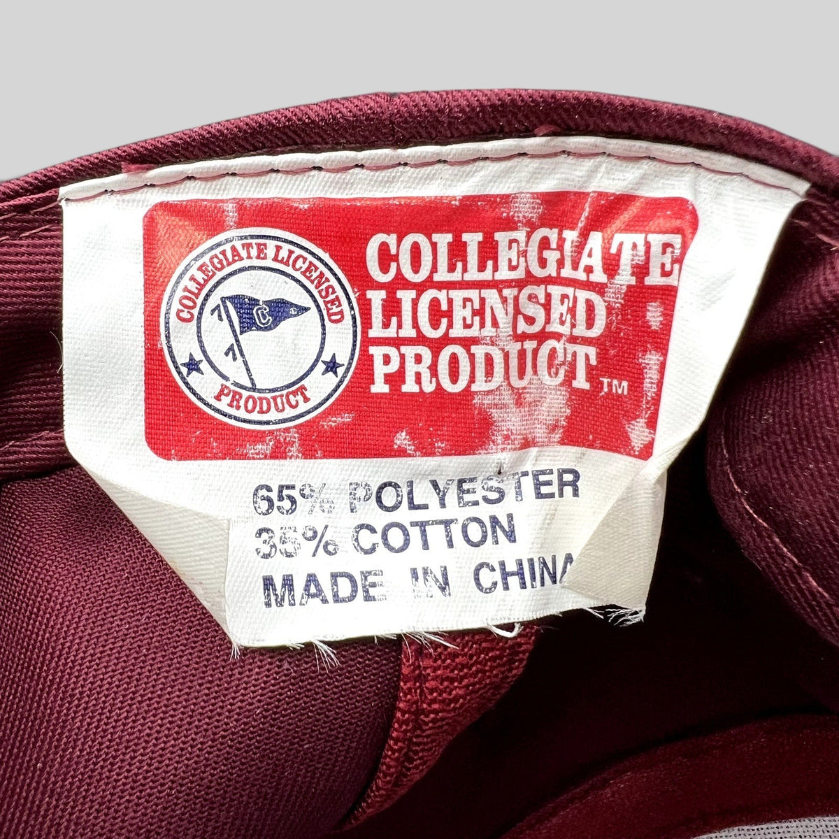 Raree Finds Collegiate Licensed Product tag inside a crimson Harvard snapback hat made of polyester and cotton blend