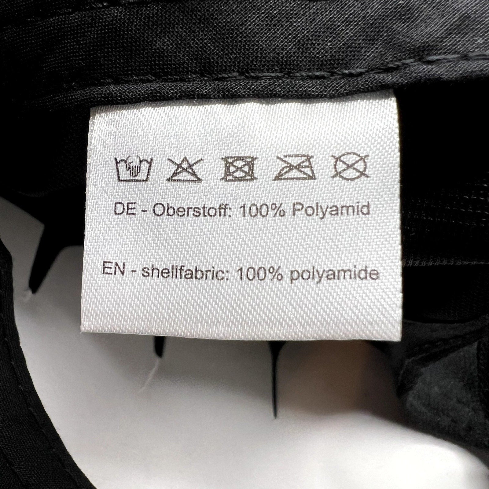Raree Finds HAWK cap interior care label showing 100% polyamide shell fabric composition and laundry instructions