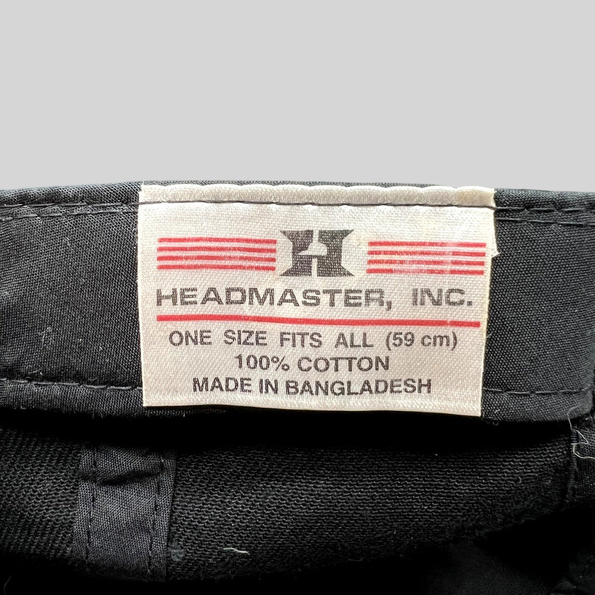 Raree Finds vintage Headmaster cotton hat interior tag with brand logo and size information on black fabric