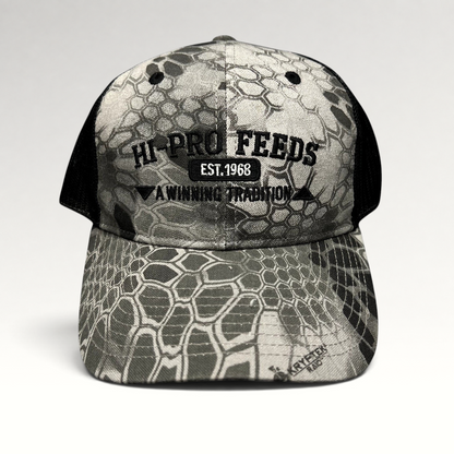 Raree Finds Hi-Pro Feeds trucker hat in gray and black Kryptek Raid camo with embroidered logo and mesh back.