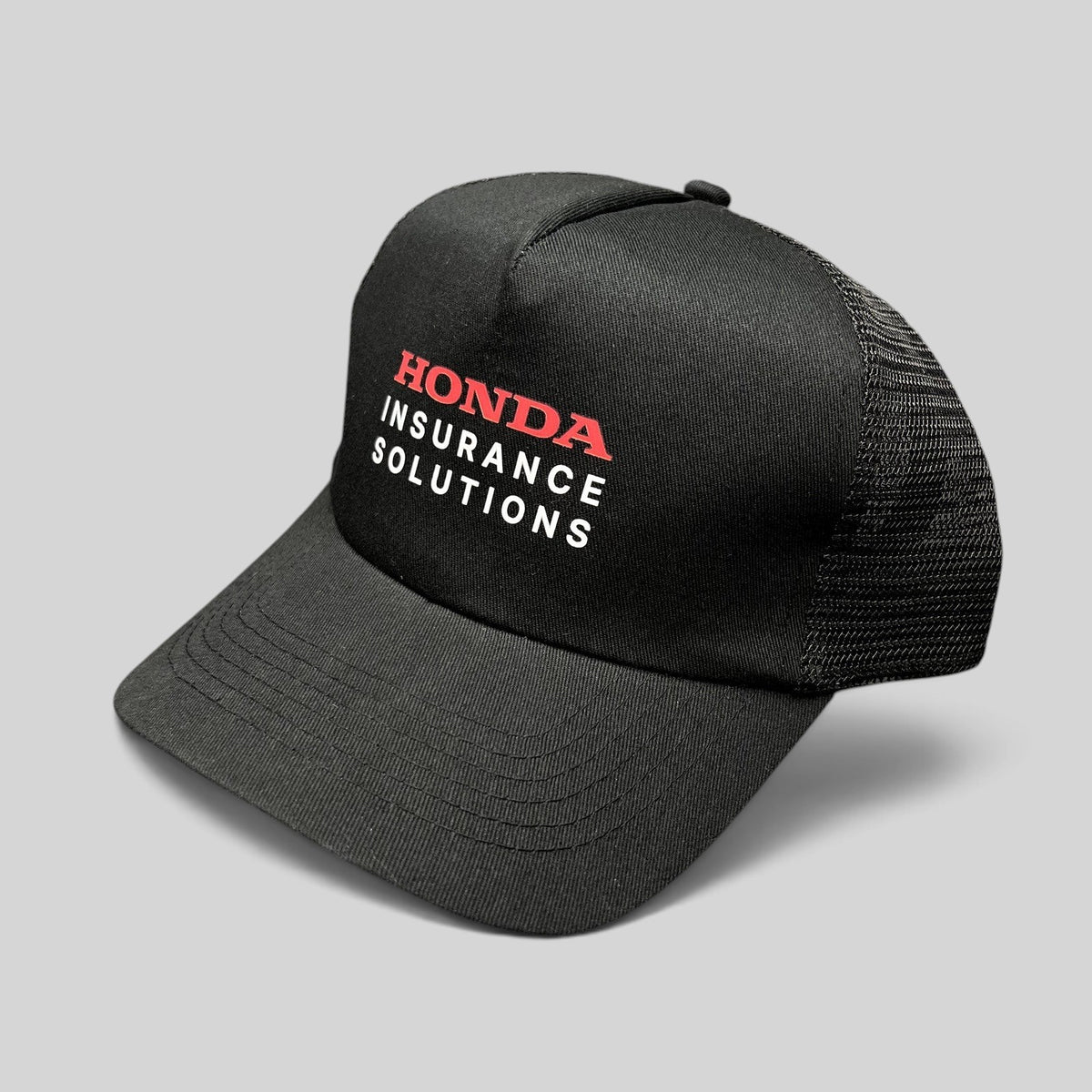 Raree Finds black mesh trucker hat with Honda Insurance Solutions logo in red and white on the structured front panel.