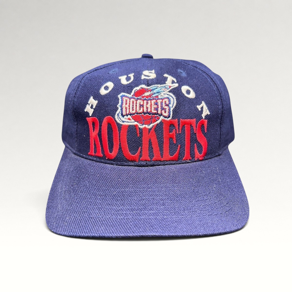 Raree Finds vintage 1990s Houston Rockets snapback hat in navy blue with red embroidered logo and green undervisor