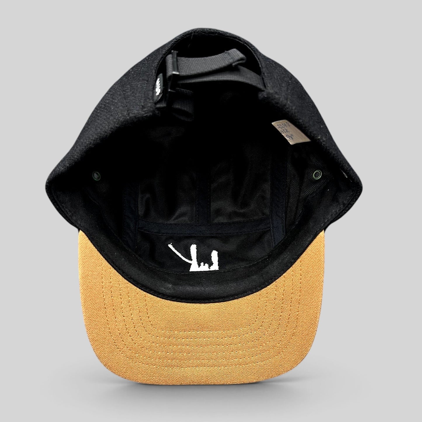 Raree Finds HUF black camp hat with tan brim and interior white script logo, featuring an adjustable strapback.