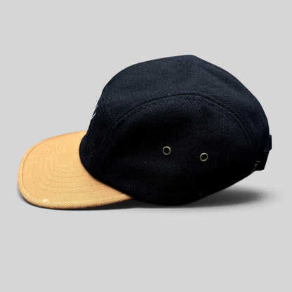 Raree Finds HUF black wool-style camp hat with a tan brim and side ventilation eyelets in a low-profile silhouette.