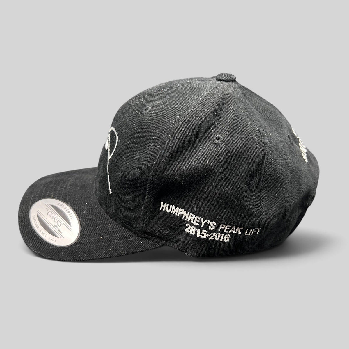 Raree Finds black Yupoong strapback hat with white Humphreys Peak Lift 2015-2016 embroidery on the side profile.