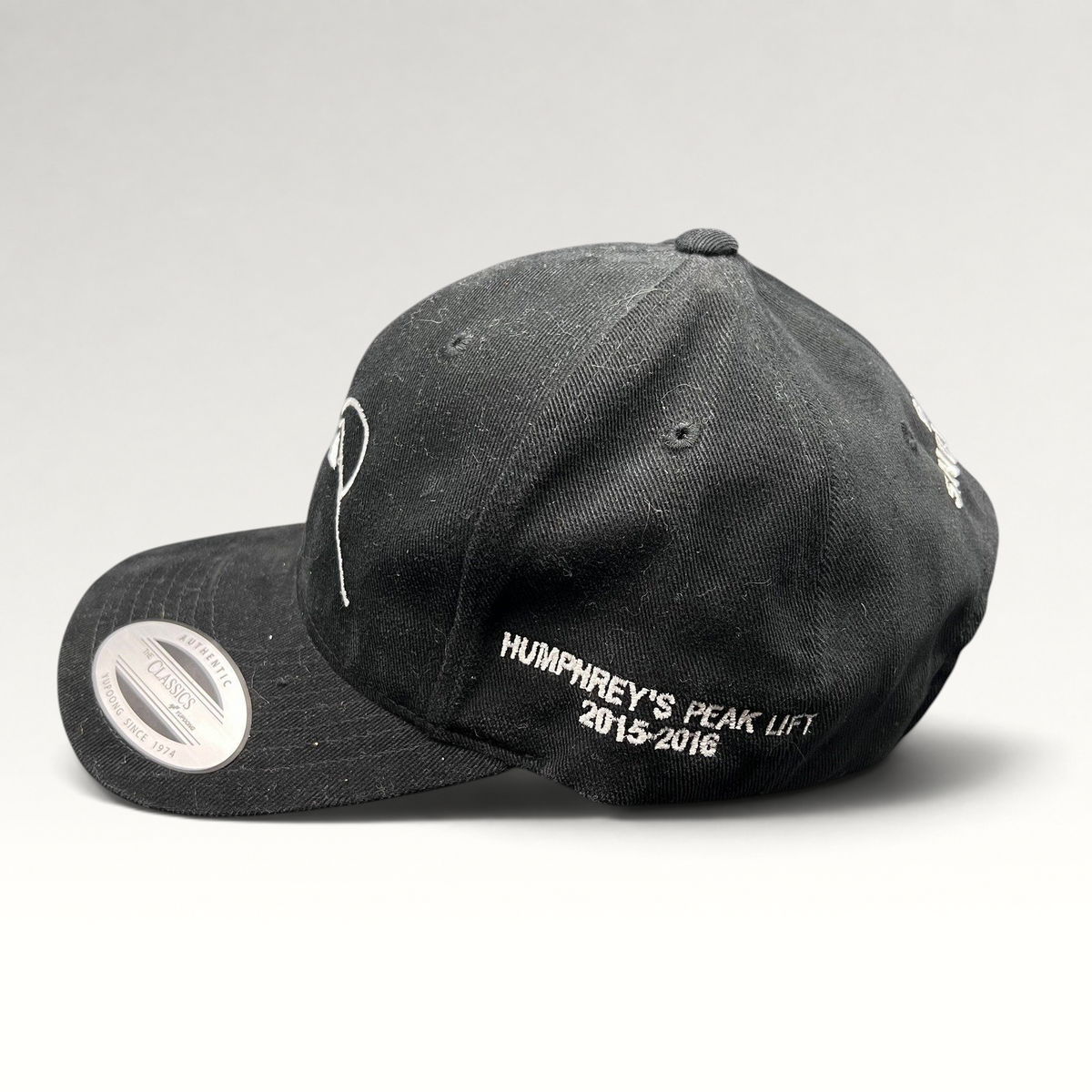 Raree Finds black Yupoong strapback hat with white Humphreys Peak Lift 2015-2016 embroidery on the side profile.
