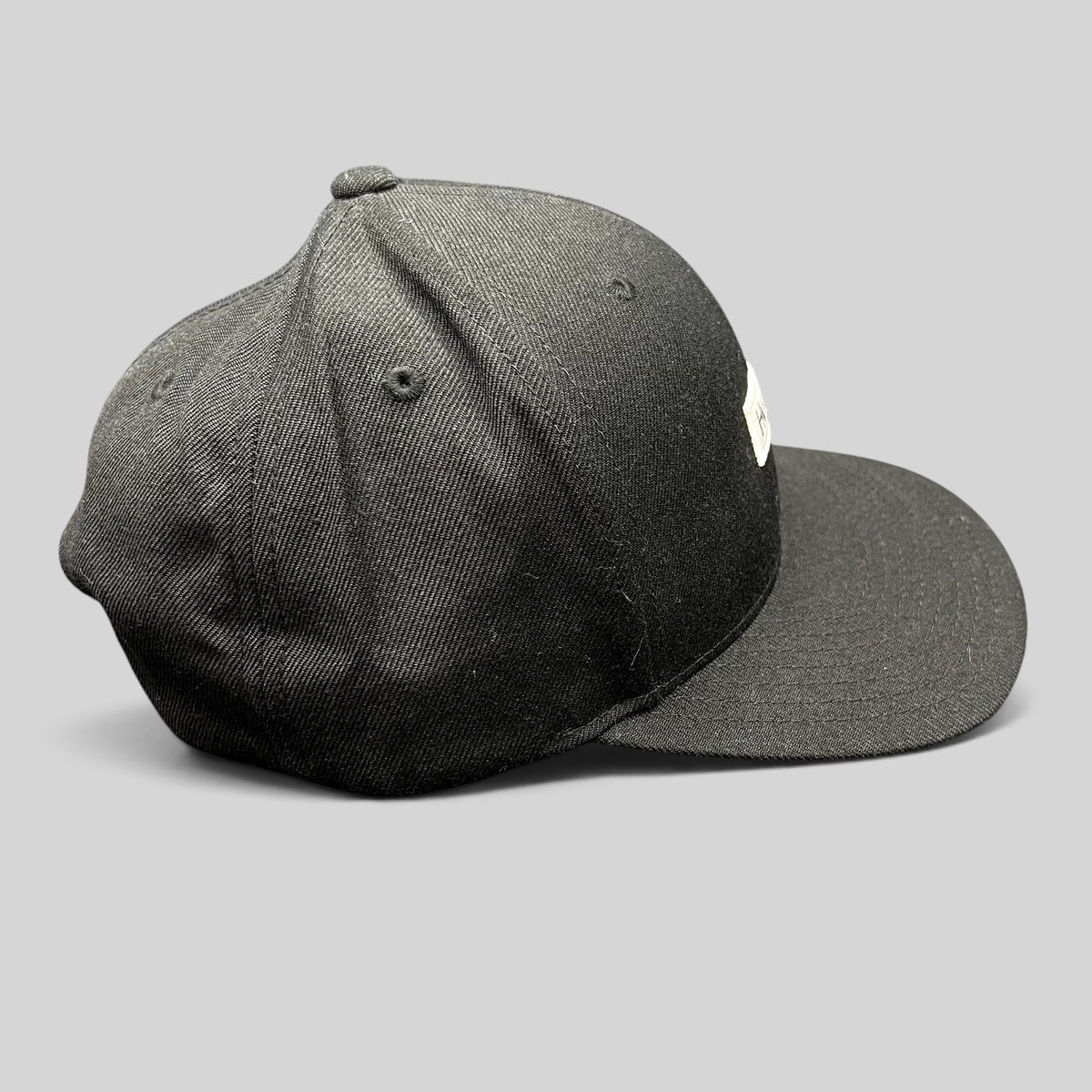 Raree Finds black Hurley snapback hat with a structured crown and flat brim, featuring a woven front logo patch.