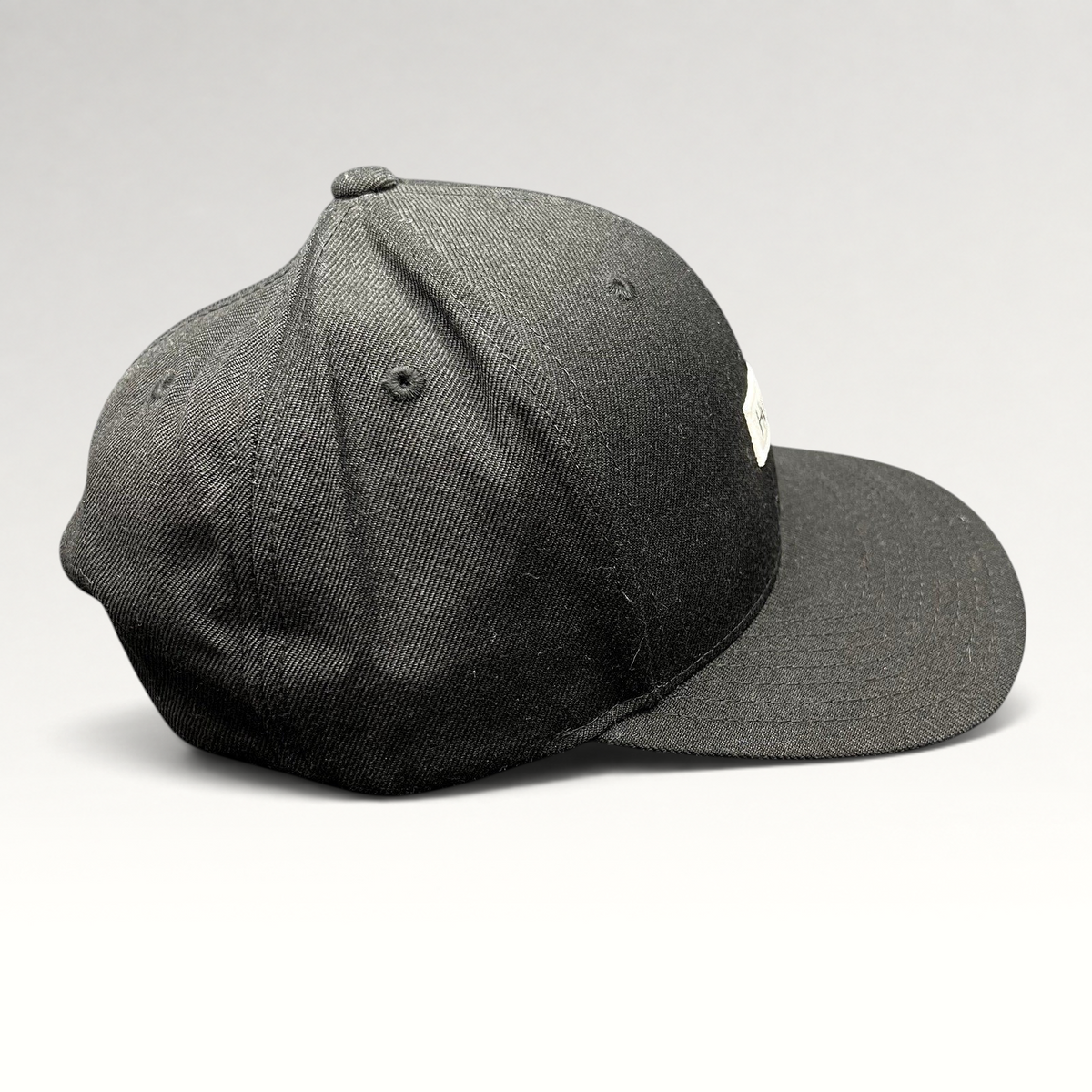 Raree Finds black Hurley snapback hat with a structured crown and flat brim, featuring a woven front logo patch.