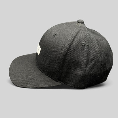 Raree Finds black Hurley Yupoong snapback hat with a structured crown and flat brim in a side profile view.