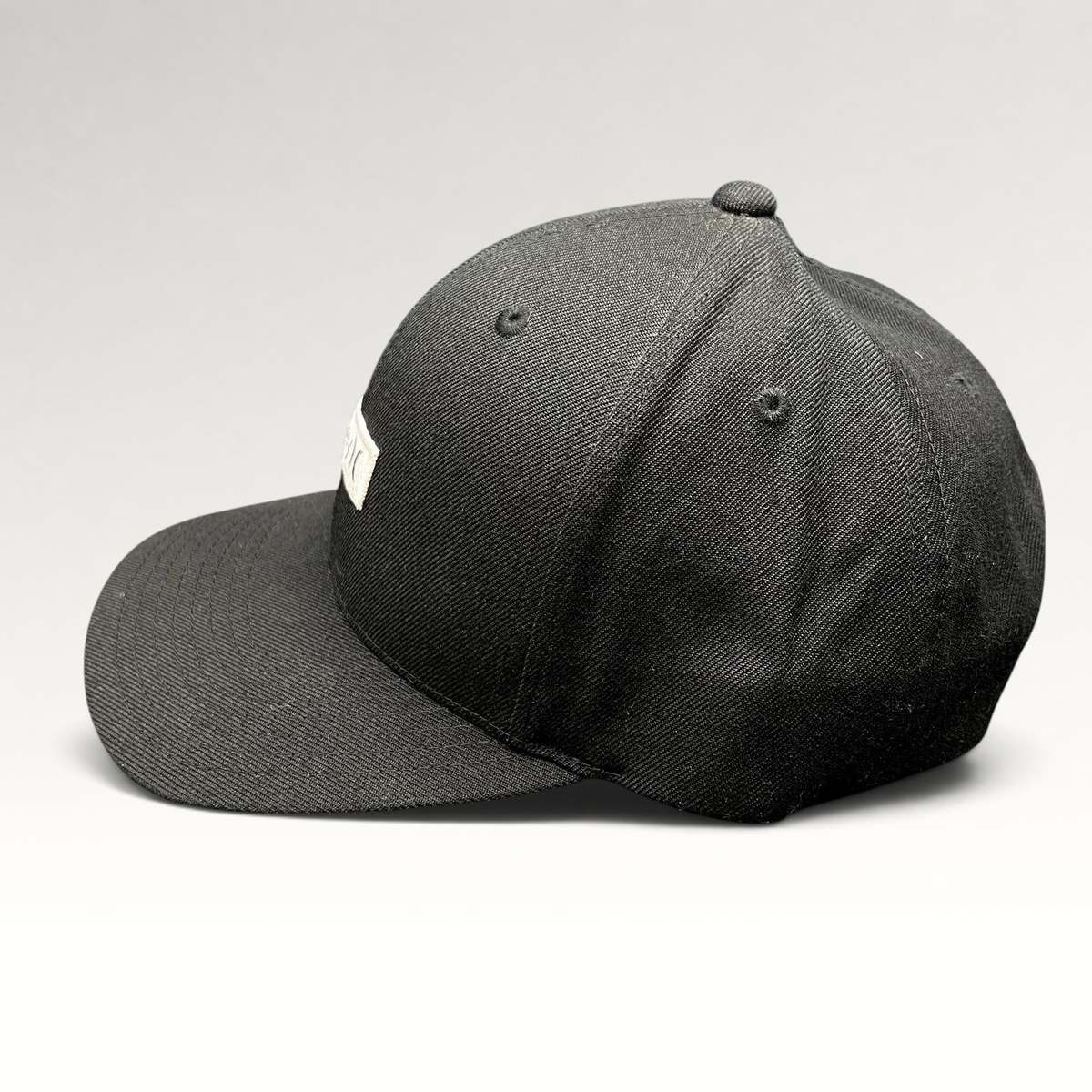 Raree Finds black Hurley Yupoong snapback hat with a structured crown and flat brim in a side profile view.