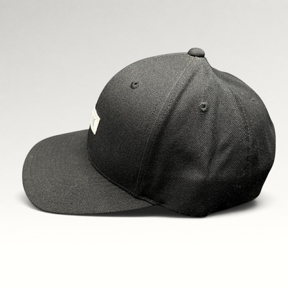 Raree Finds black Hurley Yupoong snapback hat with a structured crown and flat brim in a side profile view.
